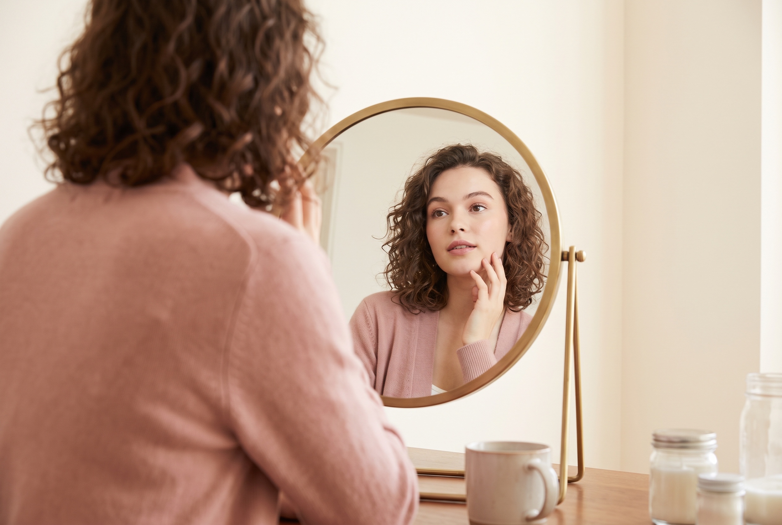 A woman studying different lip shapes on her own face on her phone